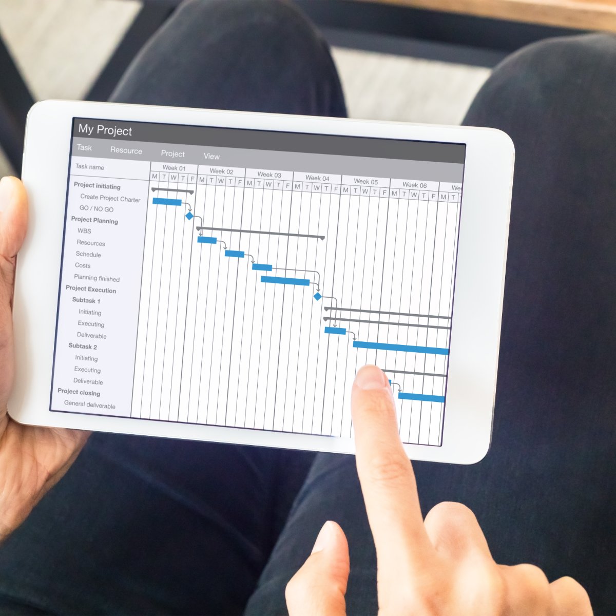Project manager working with gantt chart with planning software on digital tablet computer to update the schedule and deadlines