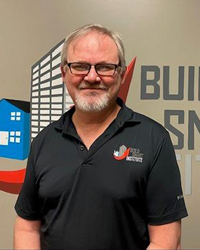 Charles Logan standing in front of the Build Smart Institute Logo