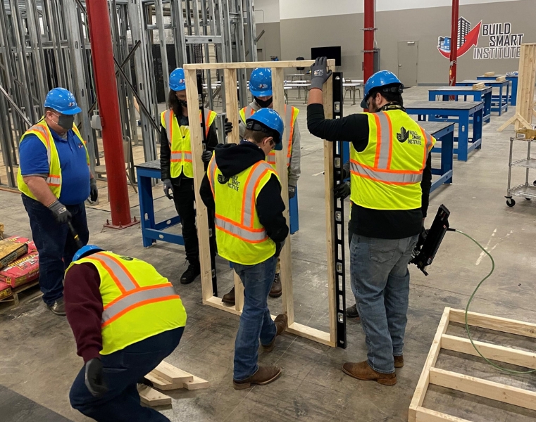 Five students work with an instructor during a carpentry trades course