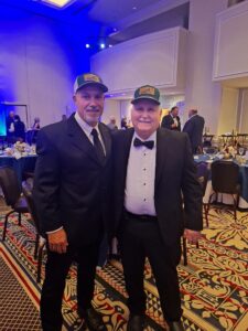 Photo of Curtis West and Charlie Smith at conference wearing hats.