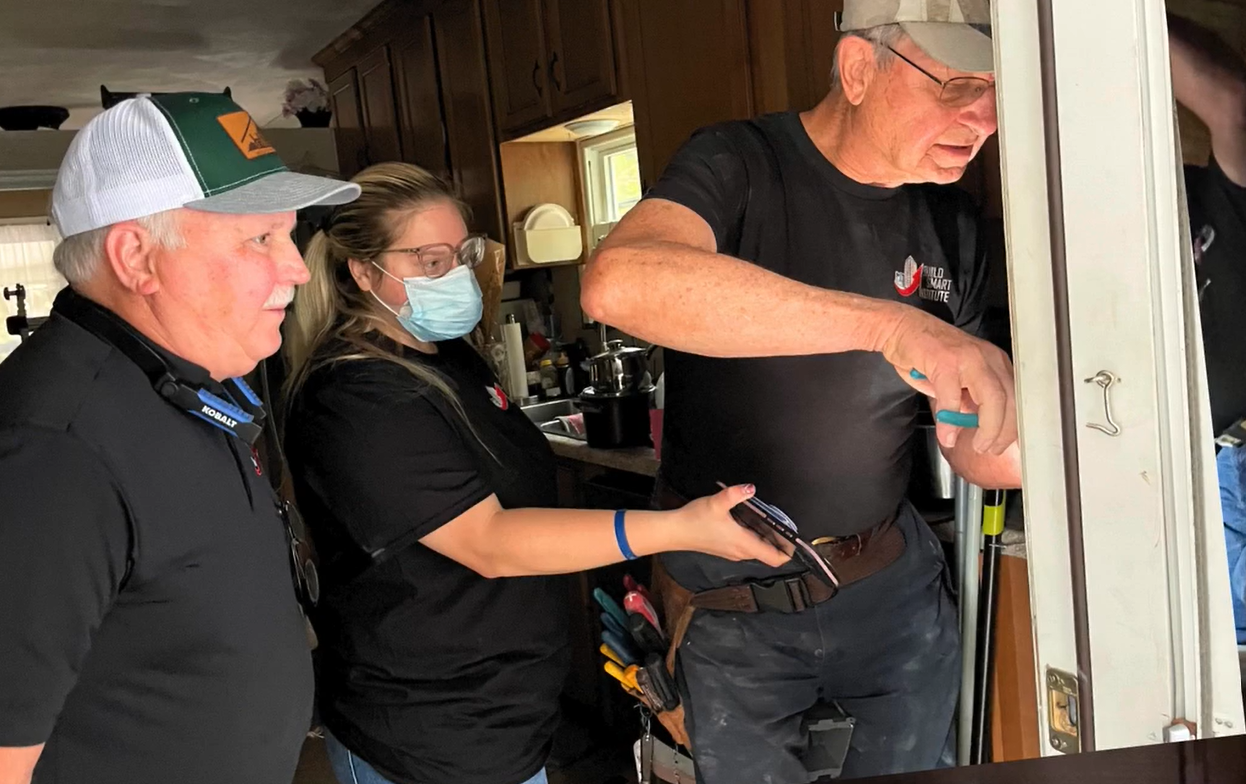 Build Smart instructors working on a door in a home during a volunteer project.